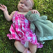 Octavia joined the competition — help win amazing prizes! baby, child, grass, outdoor, plush_toy, pink_dress, headband, footwear, knitted_slippers, unicorn, cute, infant, lying_down, nature, summer, greenery, hand, expression, soft_toy, relaxing