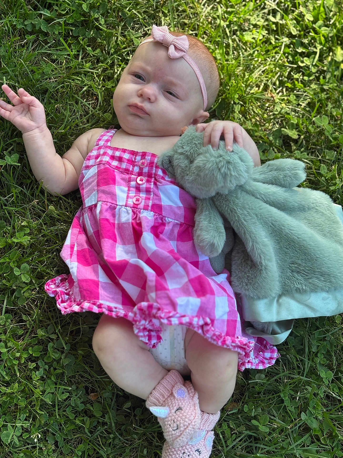 Octavia joined the competition — help win amazing prizes! baby, child, grass, outdoor, plush_toy, pink_dress, headband, footwear, knitted_slippers, unicorn, cute, infant, lying_down, nature, summer, greenery, hand, expression, soft_toy, relaxing