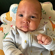 Hayes joined the competition — help win amazing prizes! baby, infant, face, onesie, clothing, hand, fist, cushion, pattern, bee, animal_print, giraffe, leaf, heart, portrait, indoor, cute, expression, child, person