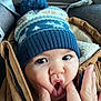 baby, child, face, hat, winter_hat, pom_pom, jacket, brown_jacket, hand, fingers, expression, funny_face, cute, close_up, indoors, warm_clothing, skin, eyes, mouth, person