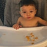 child, toddler, baby, high_chair, sitting, shirtless, face, pouting, short_hair, indoor, home, kitchen, tray, food, snacks, crumbs, chair, portrait, phone_screenshot, warm_lighting