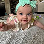 Anya is registered to the contest to win money with this photo: baby, infant, child, headband, bow, blue_eyes, smile, tummy_time, blanket, carpet, living_room, toy, rattle, portrait, close_up, cute, one_person, indoor, skin, play