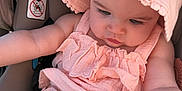 Anya is registered to the contest to win money with this photo: baby, infant, sun_hat, pink_outfit, car_seat, warning_label, seat, chubby_legs, baby_arms, face, eyelashes, looking_down, cute, adorable, pale_skin, closeup, portrait, ruffles, fabric, summer