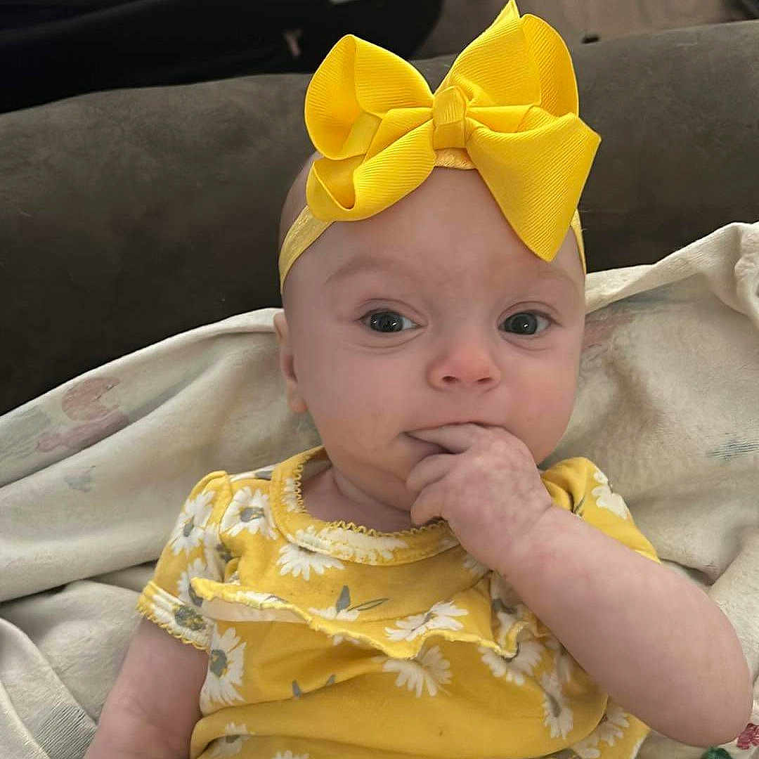 Scarlet is registered to the contest to win money with this photo: accessories, baby, cap, clothing, costume, couch, cushion, dress, face, formalwear, furniture, hat, head, headband, homedecor, person, photography, portrait, t_shirt, tie