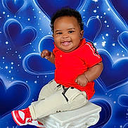 Kaysn Miller is registered to the contest to win money with this photo: baby, child, smiling, red_shirt, sneakers, pedestal, portrait, studio_photography, blue_background, hearts, stars, happy, cute, curly_hair, clothing, sitting, infant, person, fashion, joyful