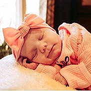 Amberley joined the competition — help win amazing prizes! baby, sleeping, pink_clothing, headband, bow, blanket, soft_texture, indoor, natural_light, cozy, peaceful, infant, portrait, cute, child, resting, warm_colors, closeup, adorable, newborn