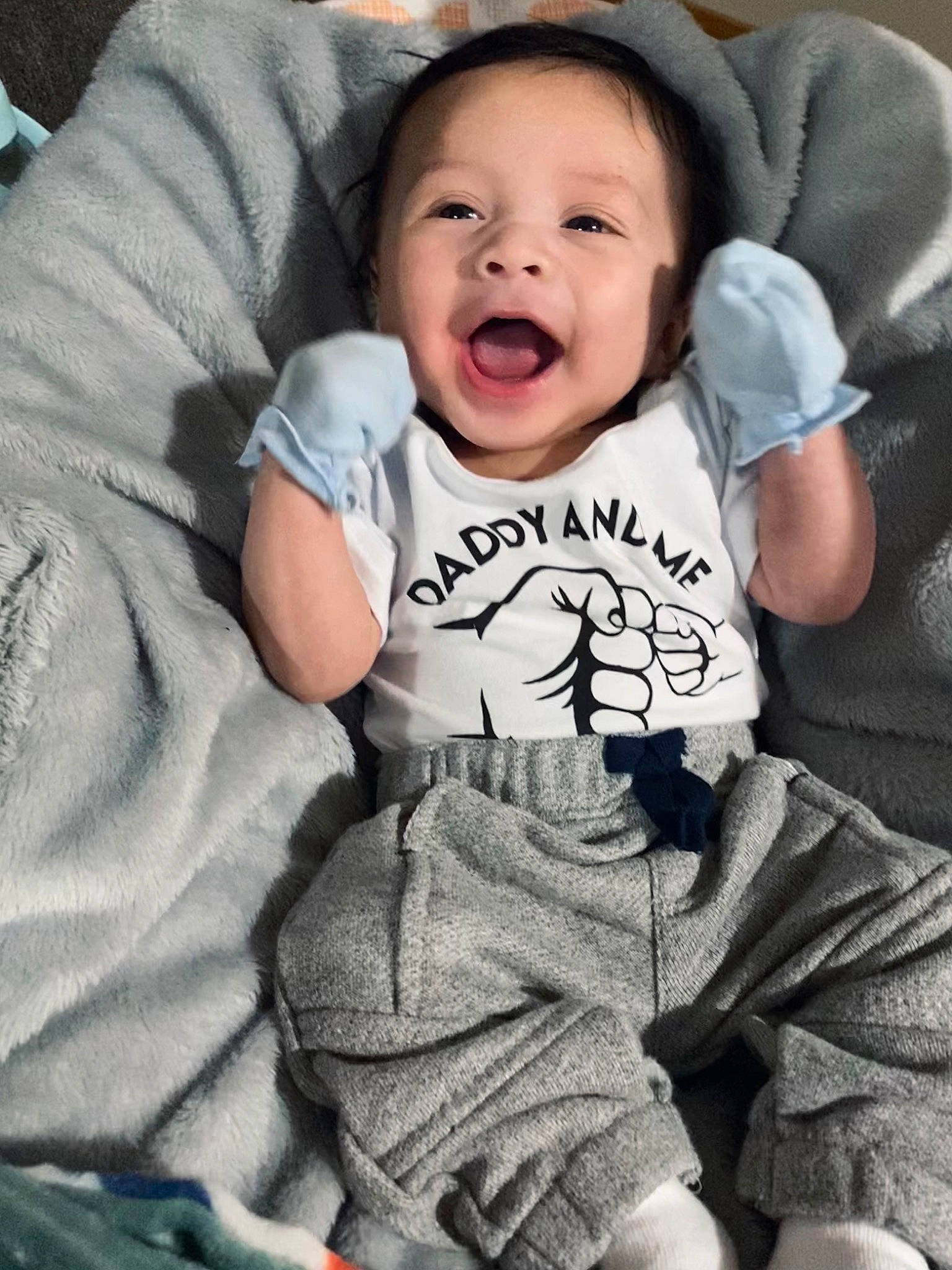 Cruz is registered to the contest to win money with this photo: arm, baby, baby_toddler_clothing, cheek, comfort, cool, eye, face, facial_expression, finger, flash_photography, gesture, grey, happy, person, skin, sleeve, smile, t_shirt, textile