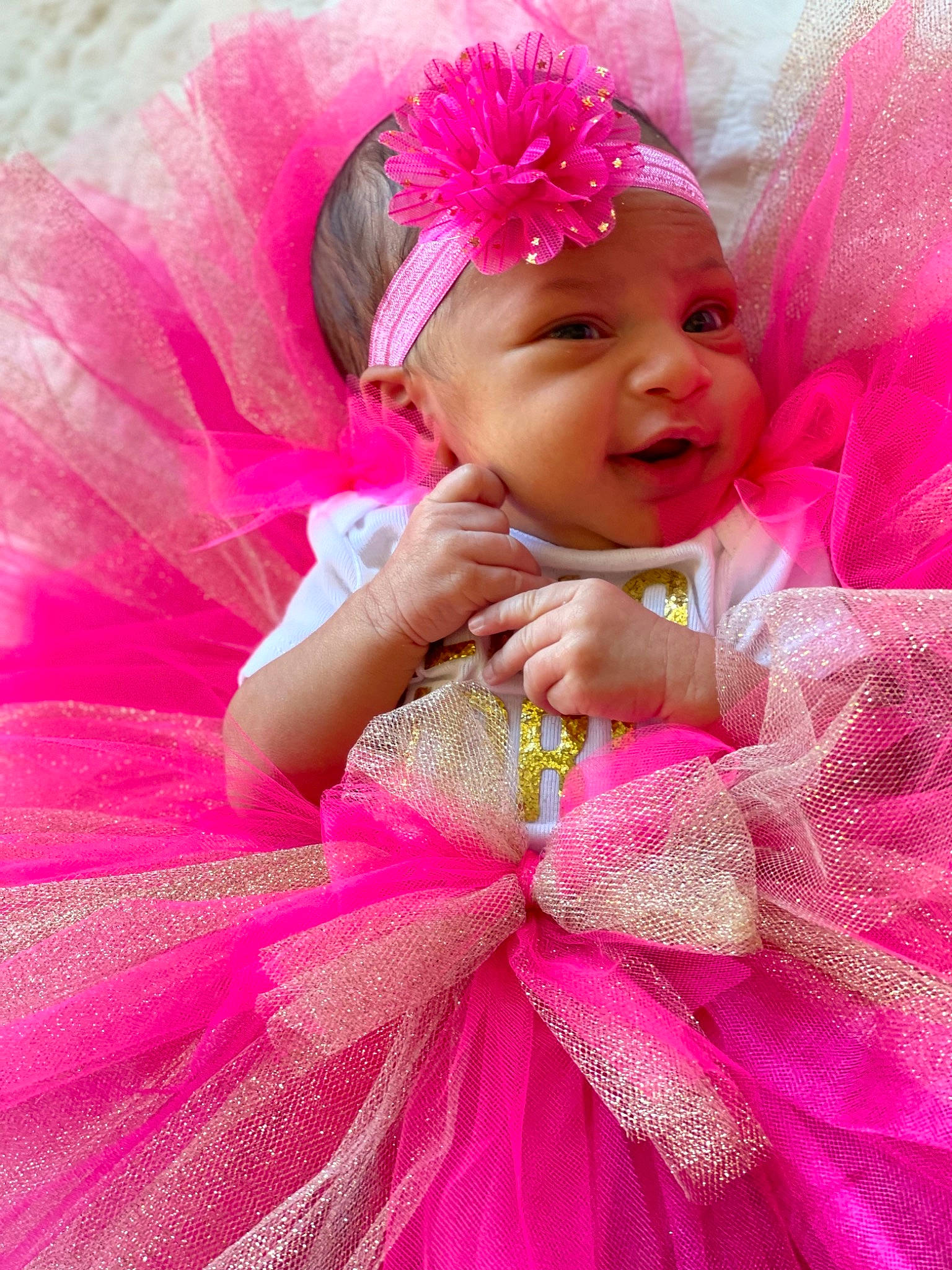 Caliana is registered to the contest to win money with this photo: baby, baby_toddler_clothing, child, dress, event, fashion_accessory, fun, hair_accessory, happy, headband, headpiece, headwear, magenta, peach, person, petal, pink, purple, red, smile