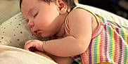 Charlotte participe au concours pour gagner de l'argent avec cette photo : baby, sleeping, infant, pillow, striped_clothing, yellow_flower_patch, star_pattern, closeup, indoors, soft_lighting, peaceful, child, cute, resting, portrait, young_child, skin, hair, hand, cozy