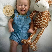 Gabriel joined the competition — help win amazing prizes! baby, infant, denim_overalls, smiling, plush_giraffe, stuffed_animal, milestone_marker, wooden_plaque, happy, cute, lying_down, soft_blanket, indoor, child, three_months, portrait, toy, young_child, infant_clothing, celebration