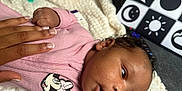 Elaiya is registered to the contest to win money with this photo: adult_hand, baby, black_and_white, blanket, closeup, curly_hair, eyes_open, face, hand, indoor, infant, lying_down, minnie_mouse, mouth_open, newborn, pattern_board, pink_clothing, skin, soft_texture, symbols