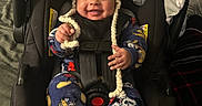 William joined the competition — help win amazing prizes! baby, blanket, car_seat, child, clothing, cozy, cute, happy, indoors, infant, knitted_hat, pajamas, person, pom_pom, portrait, seatbelt, sitting, smile, soft, warm