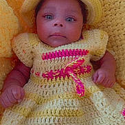 Dream is registered to the contest to win money with this photo: baby, infant, crochet_dress, yellow, hat, knitted_background, portrait, child, cute, newborn, person, smile, indoors, closeup, face, skin, hand, foot, fashion, colorful
