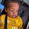 Omari joined the competition — help win amazing prizes! baby, casual, child, closeup, clothing, construction_vehicle_print, curly_hair, expression, face, indoors, infant, person, portrait, resting, seatbelt, sitting, stroller, toddler, yellow_shirt, young_child