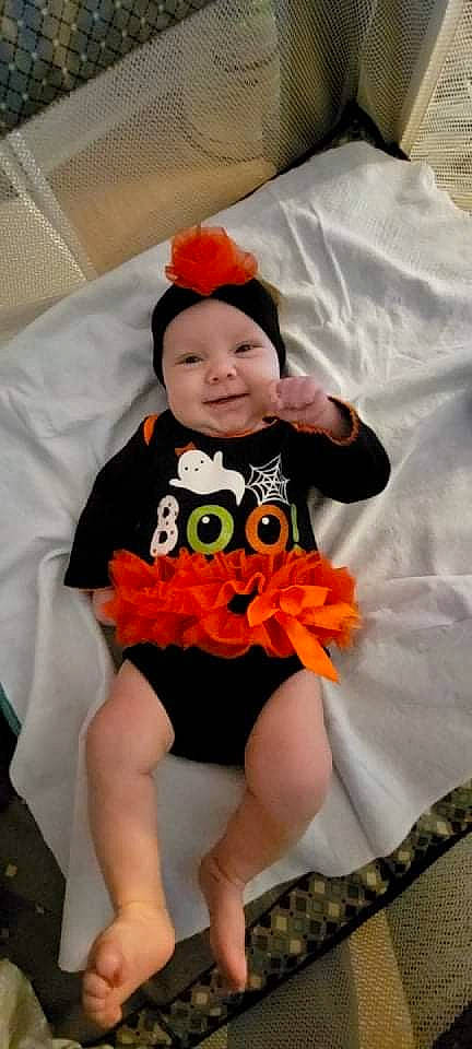 Ivy joined the competition — help win amazing prizes! baby, baby_products, baby_toddler_clothing, child, costume, event, font, happy, hat, headgear, headwear, joy, mythical_creature, orange, pattern, person, ruffle, sleeve, smile, stuffed_toy
