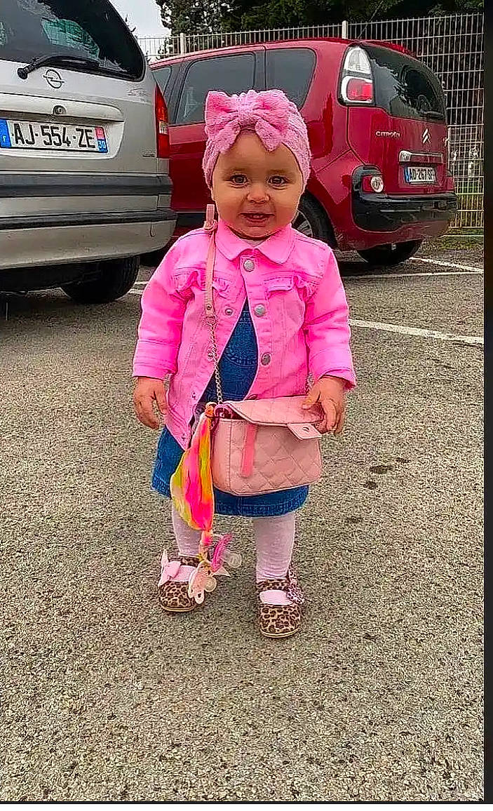 Mailya participe au concours pour gagner de l'argent avec cette photo : automotive_design, automotive_exterior, automotive_lighting, automotive_tire, bumper, car, grass, happy, headwear, land_vehicle, mode_of_transport, motor_vehicle, person, pink, public_space, smile, tire, toddler, trunk, vehicle