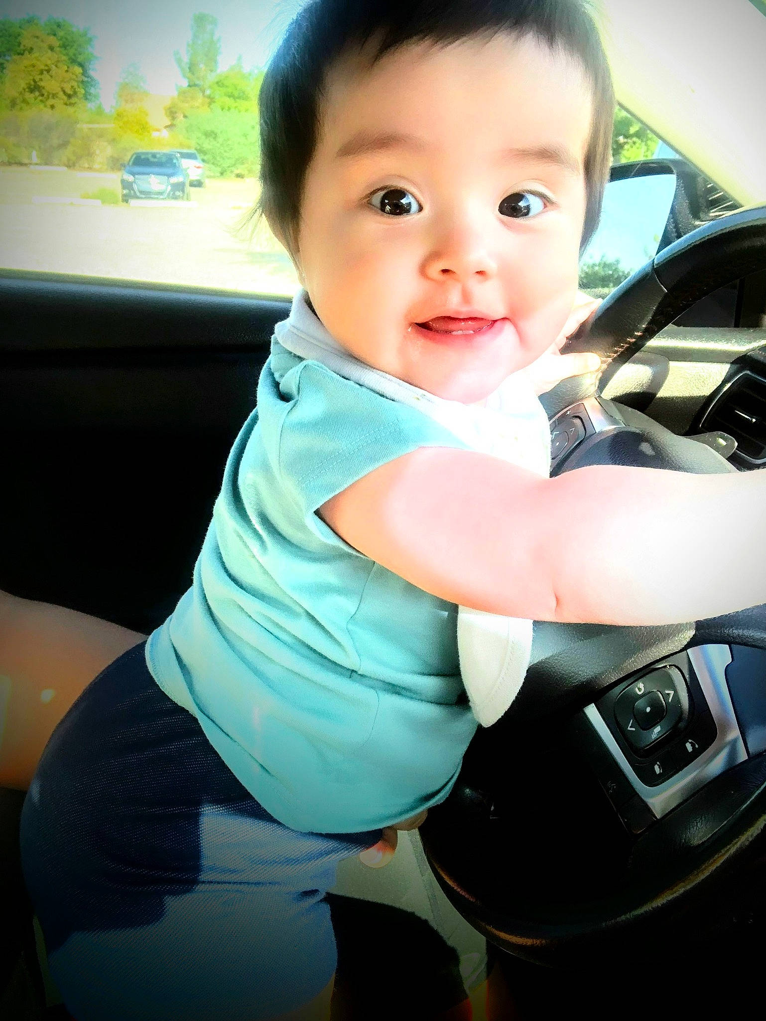 Alice is registered to the contest to win money with this photo: auto_part, automotive_design, automotive_exterior, baby, baby_toddler_clothing, car_seat, child, electric_blue, family_car, finger, flash_photography, happy, head, person, personal_luxury_car, sleeve, smile, steering_wheel, t_shirt, toddler