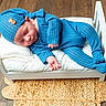 Oliver joined the competition — help win amazing prizes! baby, sleeping, blue_outfit, knitted_hat, small_bed, cushion, wooden_floor, woven_rug, infant, peaceful, indoor, cute, resting, child, portrait, cozy, newborn, soft_lighting, relaxing, baby_clothes
