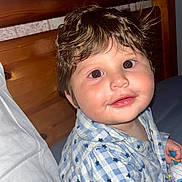 Jax is registered to the contest to win money with this photo: baby, child, portrait, indoor, wood, bed, pillow, clothing, star_pattern, blue, white, face, eyes, hair, smile, cute, infant, person, young, expression