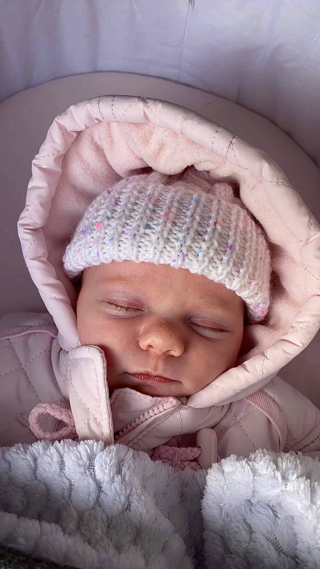 Ada is registered to the contest to win money with this photo: baby, baby_products, baby_sleeping, cap, cheek, child, close_up, comfort, eye, face, headgear, headwear, knit_cap, linens, mouth, nose, person, pink, skin, toddler