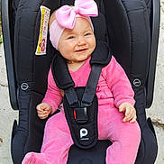 Lexy participe au concours pour gagner de l'argent avec cette photo : baby, pink_outfit, headband, pink_bow, car_seat, black_car_seat, smiling, infant, child, outdoor, concrete_floor, toy, happy, straps, safety_harness, cute, person, footwear, baby_clothing, playful