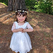 Kaicy a rejoint le concours — aidez-le/la à gagner de superbes lots ! bracelet, celebration, child, cute, flower_crown, forest, girl, grass, happy, leaves, nature, necklace, outdoor, portrait, shoes, smile, sunlight, tree, white_dress, young