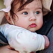 Charlie participe au concours pour gagner de l'argent avec cette photo : baby, child, face, hat, pink, onesie, hand, person, portrait, closeup, cute, infant, expression, skin, eyebrows, eyelashes, holding, clothing, outdoor, soft_light