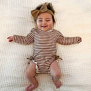 Ava joined the competition — help win amazing prizes! baby, blanket, bow, child, cute, foot, hand, happy, headband, indoors, infant, lying_down, onesie, person, portrait, skin, smiling, striped_clothing, toddler, young