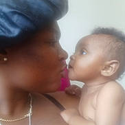 Ke'Myla joined the competition — help win amazing prizes! baby, infant, mother, parent, child, adult, kiss, affection, bonding, portrait, close_up, face, eyes, smile, holding, indoors, soft_focus, warm_lighting, jewelry, family