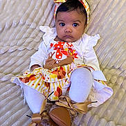 Tru is registered to the contest to win money with this photo: baby, infant, child, headband, bow, white_clothing, patterned_skirt, boots, blanket, texture, laying_down, cute, portrait, indoors, young_child, looking_at_camera, fall_colors, ribbons, small_feet, cozy