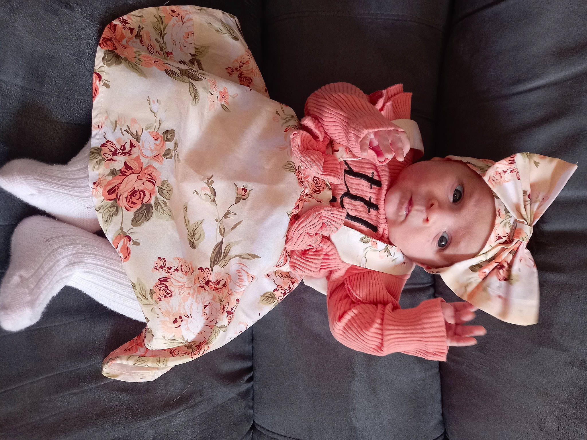 Mila participe au concours pour gagner de l'argent avec cette photo : arm, baby, baby_toddler_clothing, dress, eye, face, hand, happy, head, headgear, headwear, human_body, leg, pattern, person, petal, pink, plant, skin, sleeve