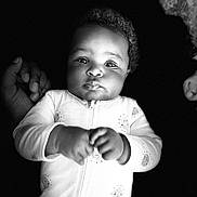 Caloni is registered to the contest to win money with this photo: baby, infant, child, portrait, black_and_white, onesie, hand, curly_hair, face, eyes, expression, cute, newborn, sleepwear, soft_lighting, support, chubby_cheeks, monochrome, young, person