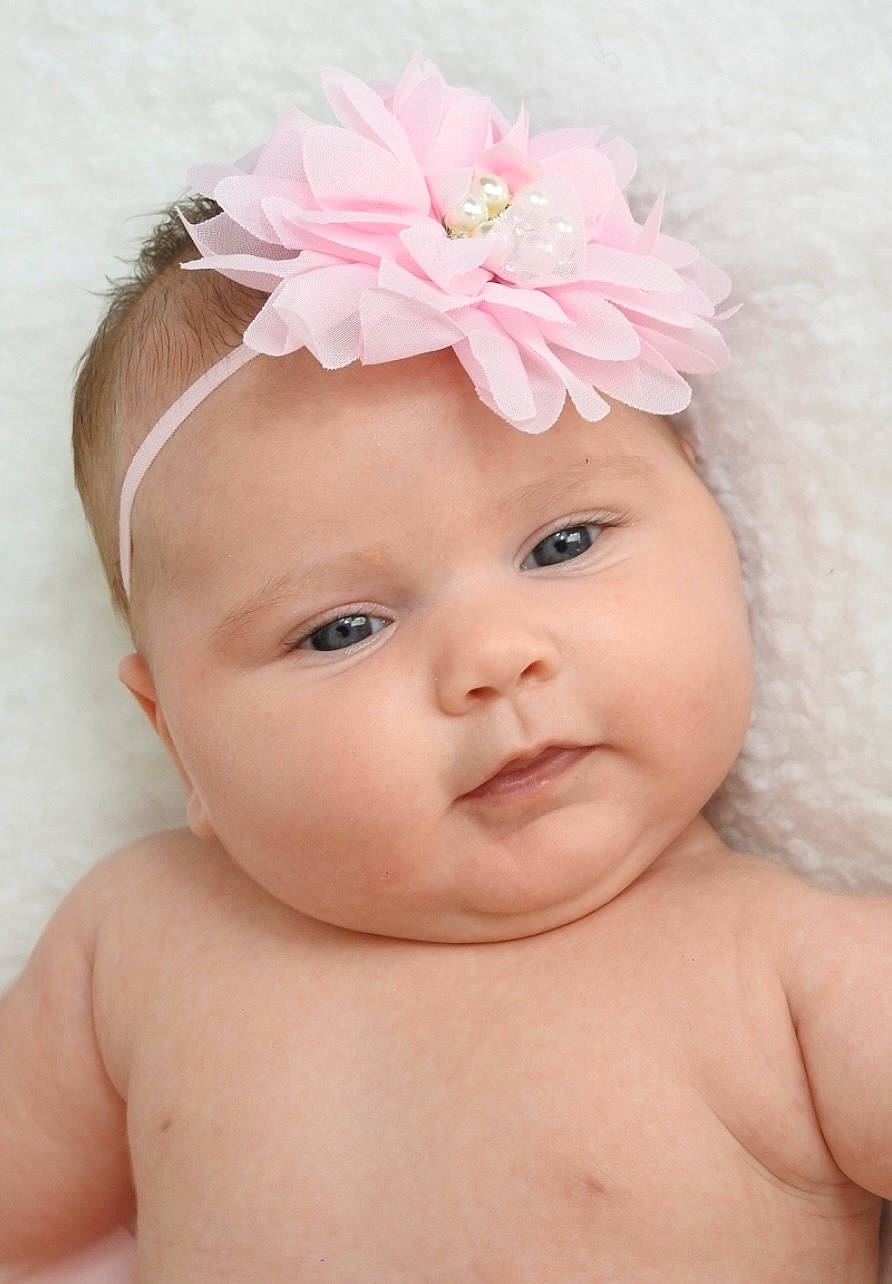 Brianna participe au concours pour gagner de l'argent avec cette photo : baby, cap, cheek, dress, eye, eyebrow, eyelash, face, flower, hand, happy, head, headgear, headpiece, headwear, lip, person, petal, pink, plant