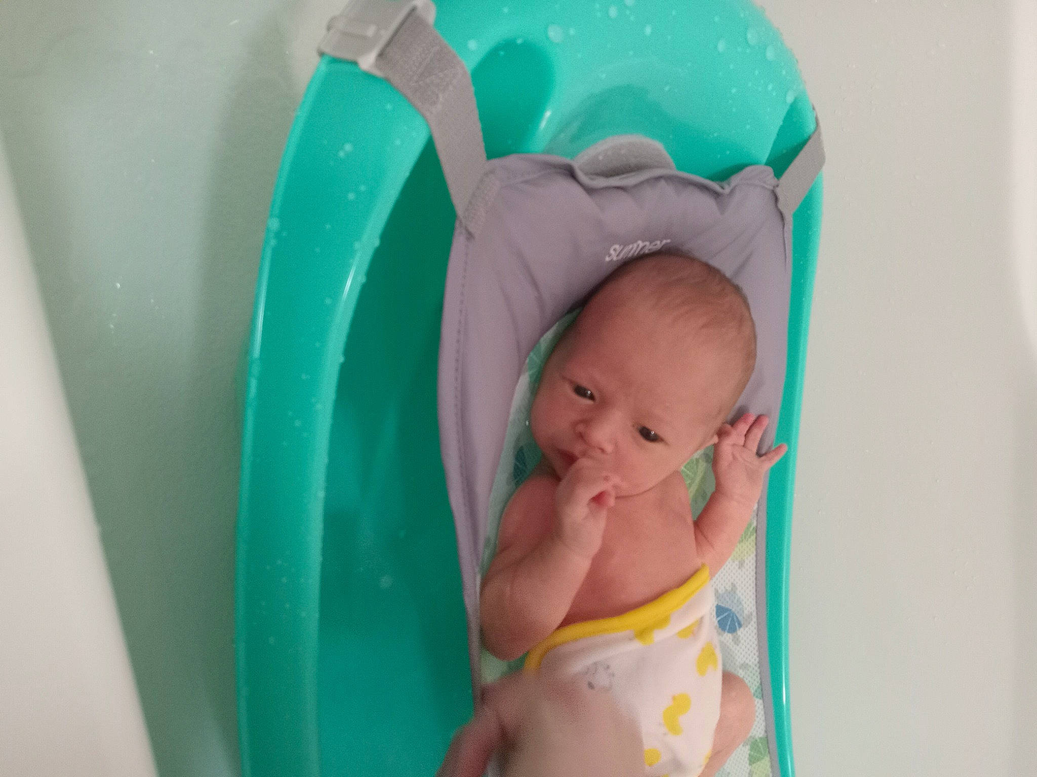 Kai is registered to the contest to win money with this photo: abdomen, aqua, baby, baby_products, baby_toddler_clothing, bathing, cap, child, comfort, event, fashion_accessory, fun, infant_bed, linens, person, plastic, play, room, sitting, skin