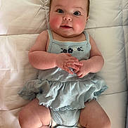 Landrie joined the competition — help win amazing prizes! baby, infant, child, cute, blue_dress, quilt, lying_down, hands, face, cheeks, eyes, skin, smile, person, indoors, soft_lighting, portrait, clothing, cute_expression, baby_fashion