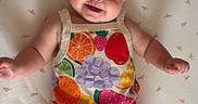 Landrie joined the competition — help win amazing prizes! baby, infant, smiling, headband, flower, pink, fruit_pattern, clothing, lying_down, blanket, cute, happy, child, portrait, skin, arm, leg, indoors, baby_girl, colorful