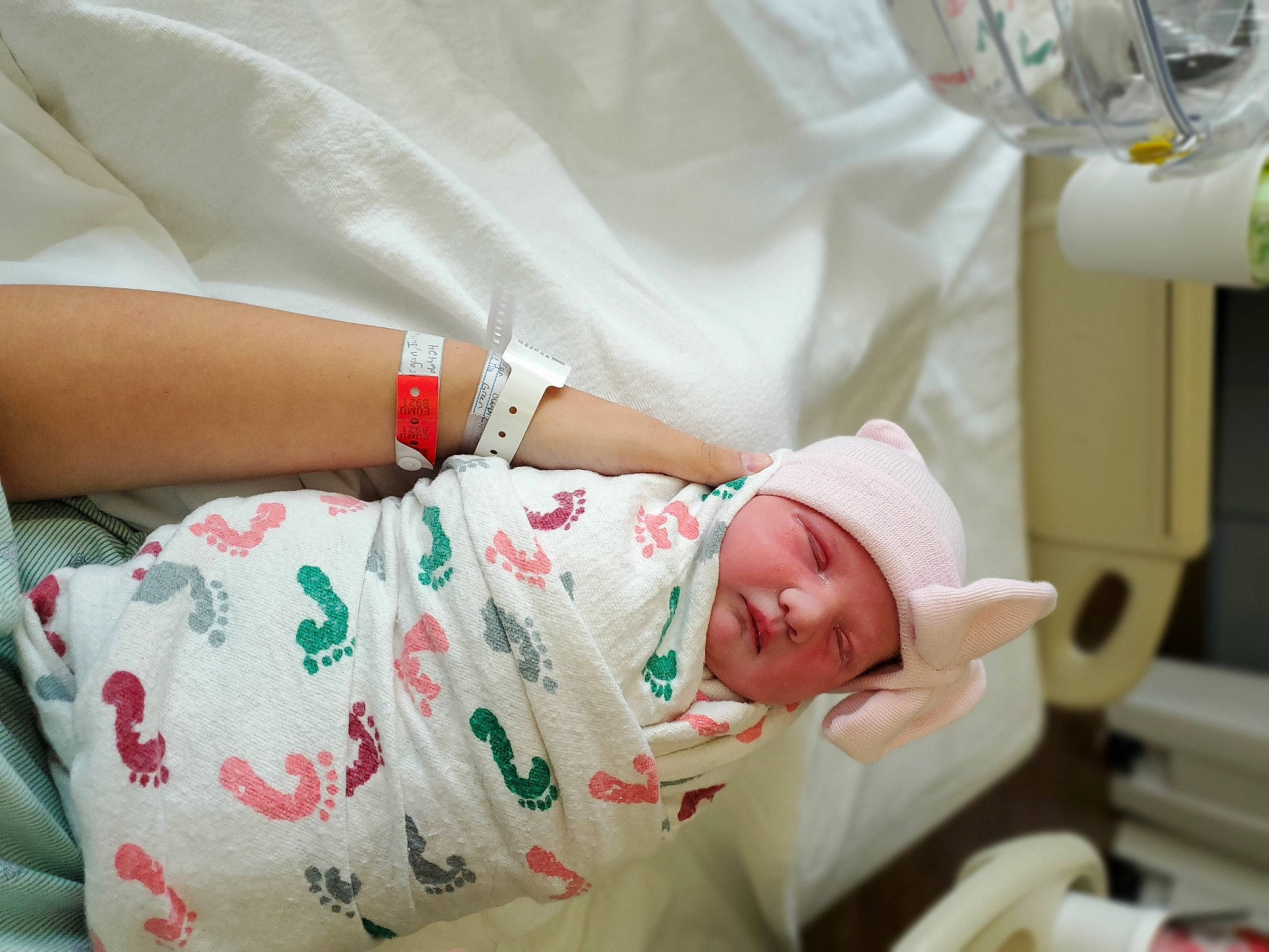 Alyson is registered to the contest to win money with this photo: baby, baby_toddler_clothing, child, comfort, elbow, finger, hand, hat, headwear, health_care, hospital, hospital_bed, human, linens, person, product, skin, sleeve, textile, toddler