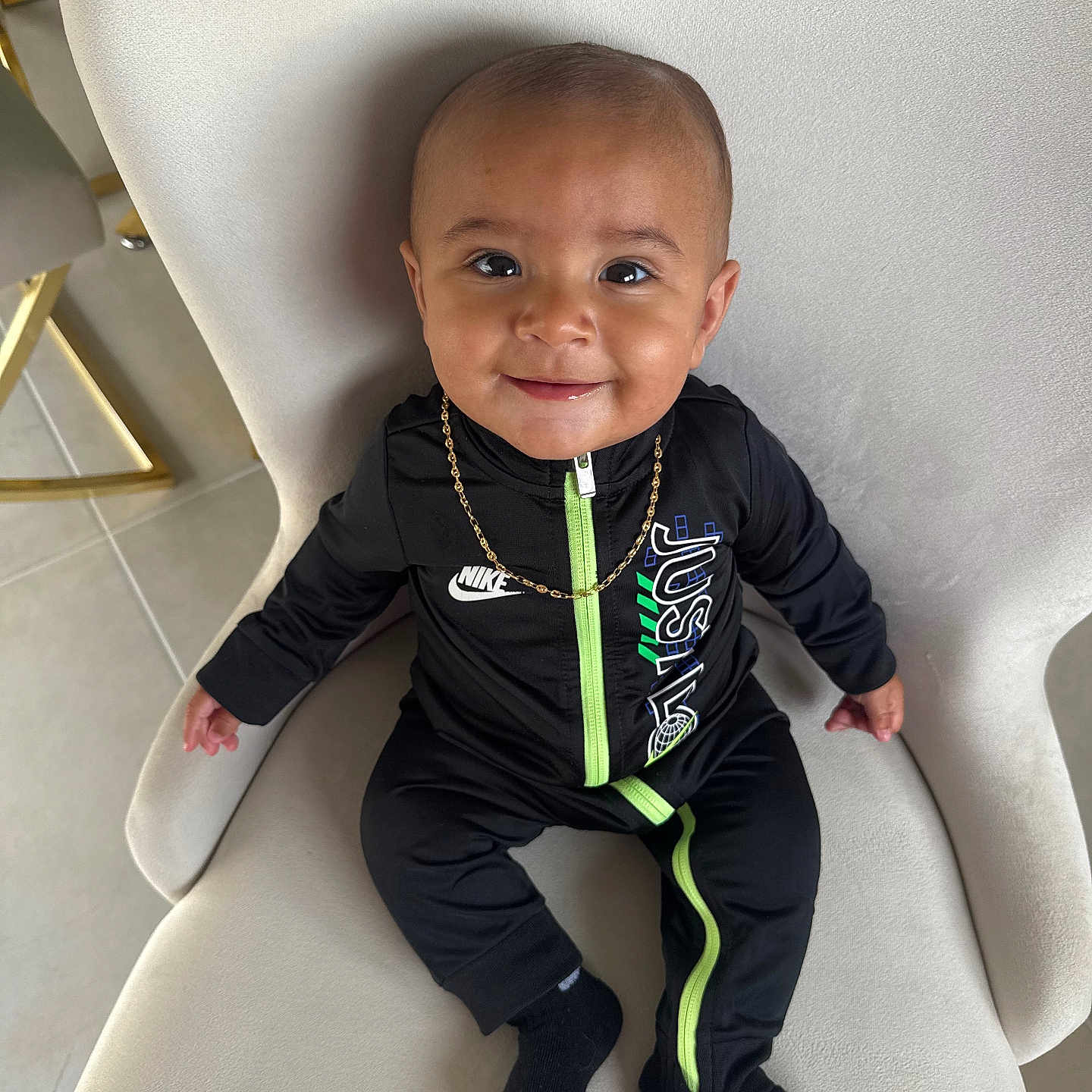 Kencio participe au concours pour gagner de l'argent avec cette photo : baby, black_clothing, black_socks, chair, child, cute, face, fashion, floor, gold_chain, happy, head, indoor, nike, person, portrait, sitting, smiling, tile_floor, young_child