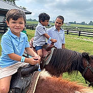 Caden joined the competition — help win amazing prizes! children, adult, ponies, horse, farm, outdoors, countryside, riding, saddle, family, portrait, smiling, boy, nature, grass, fence, barn, sky, equestrian, daylight