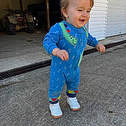 Kolter joined the competition — help win amazing prizes! toddler, child, blue_onesie, white_sneakers, smiling, outdoor, concrete, garage, atv, walking, happy, dinosaur_pattern, person, daylight, footwear, young_child, casual_clothing, concrete_driveway, sidewalk, expression