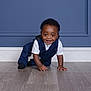 toddler, child, crawling, smiling, navy_suit, white_shirt, indoor, wooden_floor, blue_wall, paneled_wall, cute, happy, portrait, person, baby, fashion, formal_clothing, hands, feet, flooring