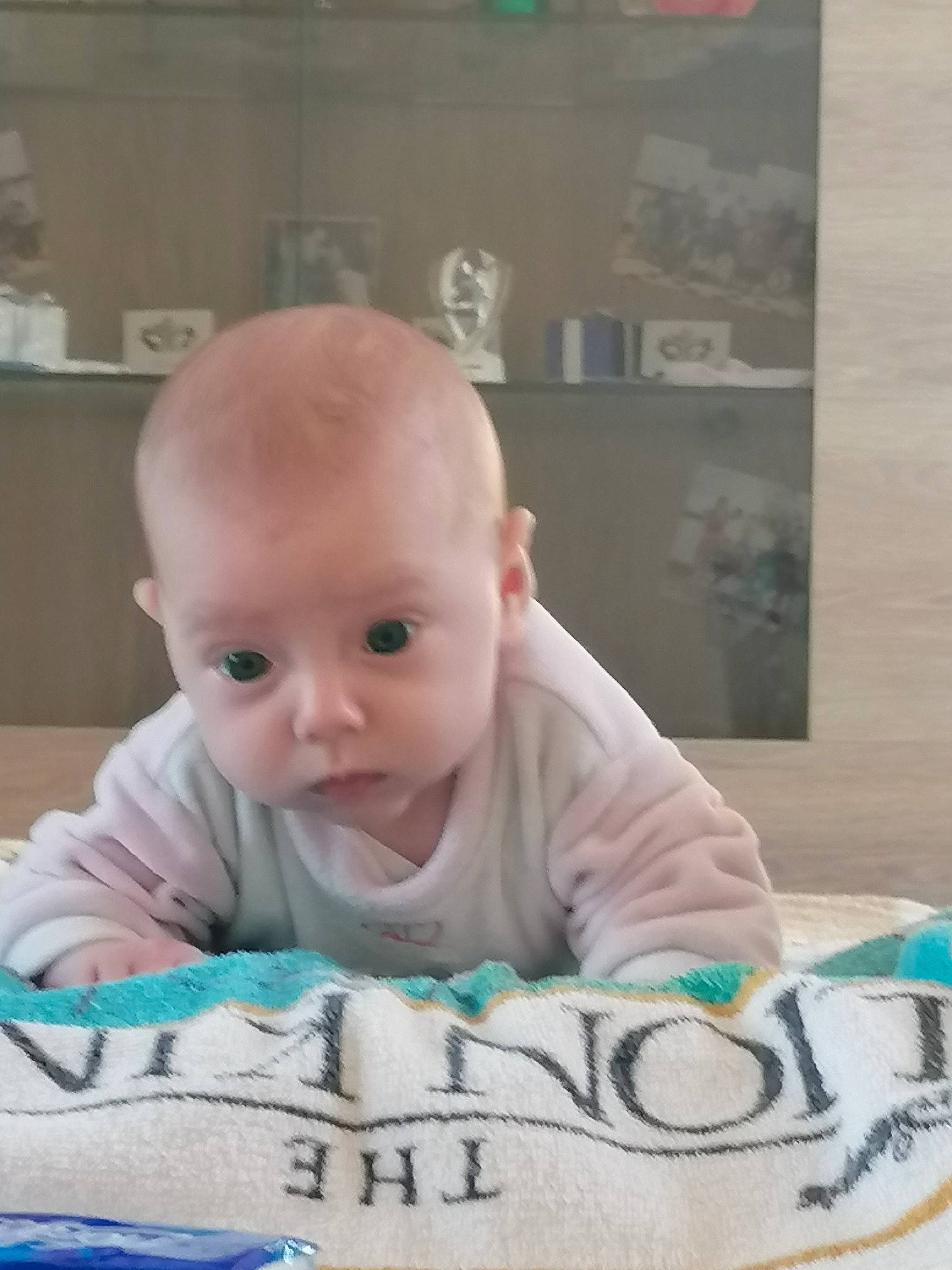 Louana participe au concours pour gagner de l'argent avec cette photo : baby, baby_products, baby_toddler_clothing, cheek, child, comfort, drinkware, facial_expression, floor, flooring, happy, linens, person, portrait_photography, room, sitting, sleeve, t_shirt, toddler, tummy_time