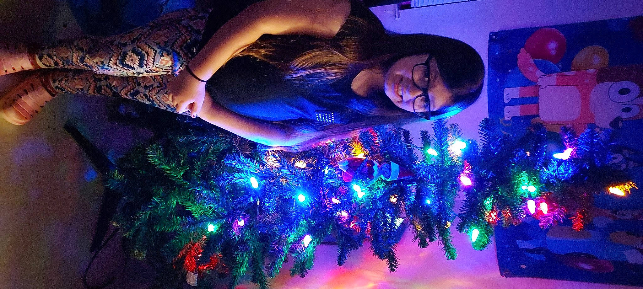 Sara is registered to the contest to win money with this photo: blue, christmas, christmas_decoration, christmas_eve, christmas_ornament, electric_blue, entertainment, event, fun, happy, joy, light, ornament, person, plant, purple, sky, smile, technology, tree