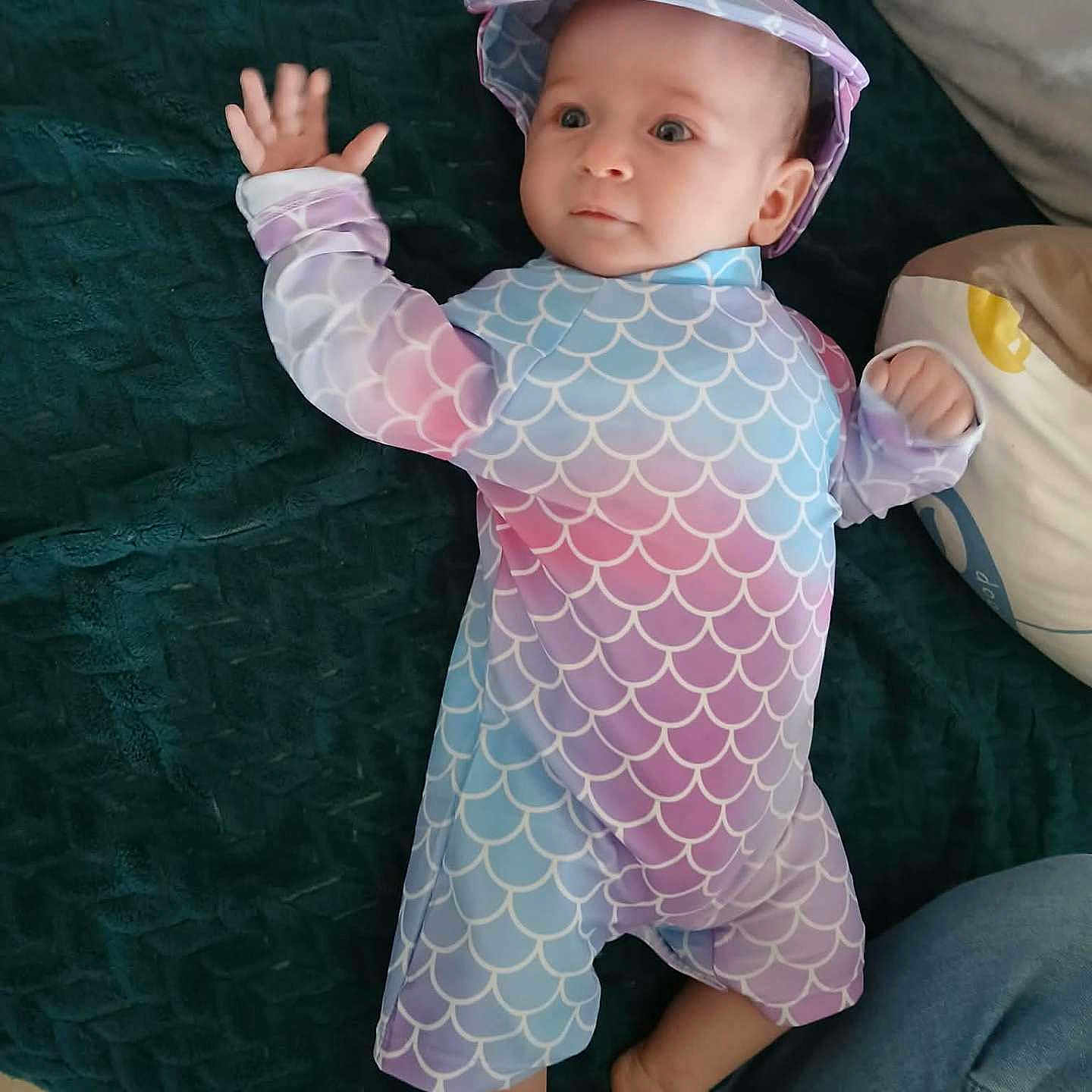 évy participe au concours pour gagner de l'argent avec cette photo : baby, infant, child, clothing, hat, lying_down, blanket, pillow, person, foot, hand, cute, indoors, colorful, pattern, fabric, face, eyes, jeans, curious