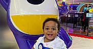 Zamir joined the competition — help win amazing prizes! toddler, child, smiling, indoor, arcade, amusement, statue, colorful, playful, happy, person, toy, fun, floor, clothing, shorts, tshirt, celebration, birthday, winking