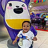 toddler, child, smiling, indoor, arcade, amusement, statue, colorful, playful, happy, person, toy, fun, floor, clothing, shorts, tshirt, celebration, birthday, winking