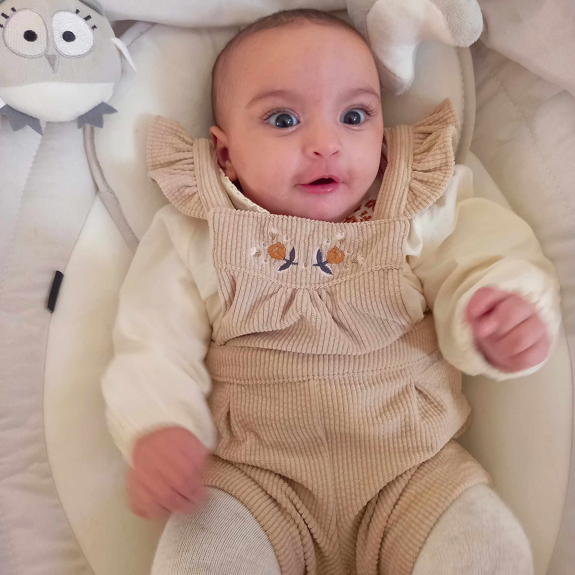 Maria participe au concours pour gagner de l'argent avec cette photo : baby, infant, child, plush_toy, stuffed_animal, cushion, clothing, beige, cream, seat, portrait, face, eyes, smile, indoor, cute, soft, furniture, young_child, cozy