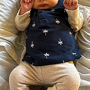 Marius participe au concours pour gagner de l'argent avec cette photo : baby, infant, child, clothing, shirt, pants, sneakers, hand, face, hair, bed, blanket, lying_down, cute, expression, fist, soft_surface, indoor, person, young_child
