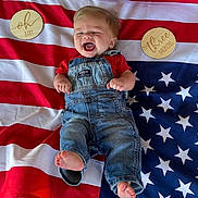 Grant joined the competition — help win amazing prizes! baby, infant, denim_overalls, red_shirt, american_flag, stars, stripes, wooden_plaques, milestone, three_months, oh_baby, happy, laughing, barefoot, lying_down, celebration, cute, child, portrait, clothing