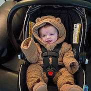 Stanley is registered to the contest to win money with this photo: baby, car_seat, infant, onesie, fuzzy_clothing, smiling, blue_eyes, seatbelt, cute, child, indoor, clothing, mitten, footwear, safety, happy, person, small, teddy_bear_style, seat